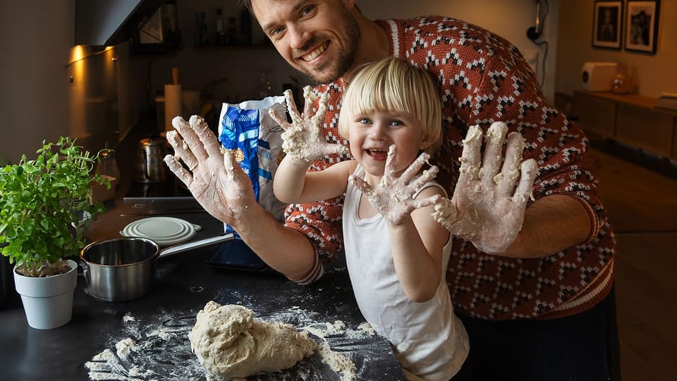Vegard og en liten jente viser fram melete hender ved kjøkkenbenken